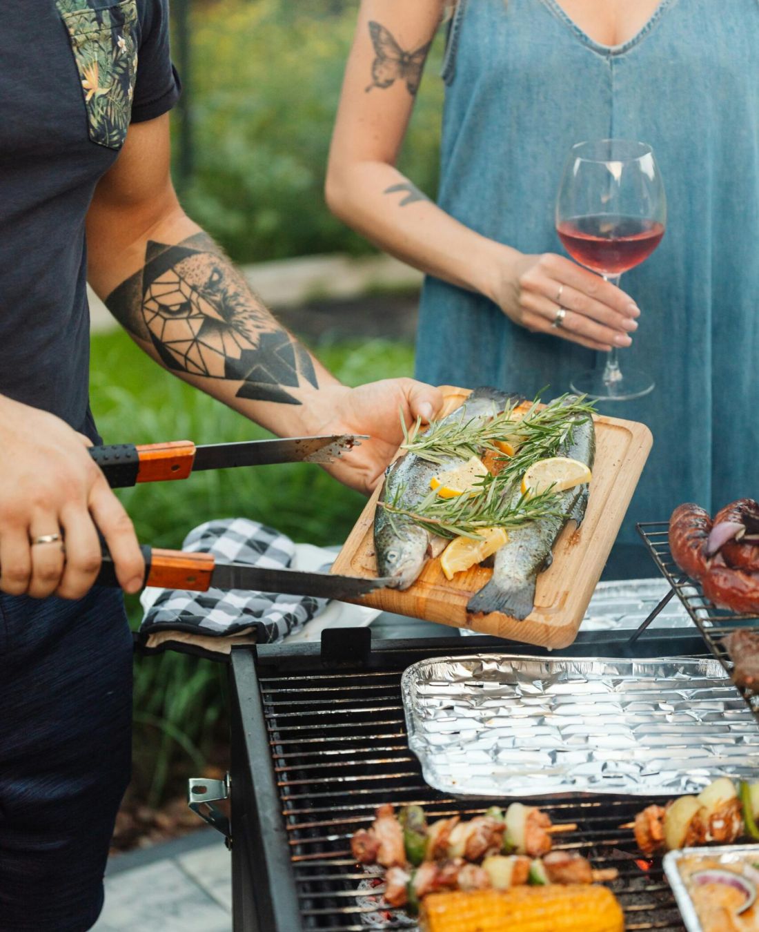 Northside Vistas apartments residents grilling fish and veggies, holding wine; an outdoor barbecue scene.